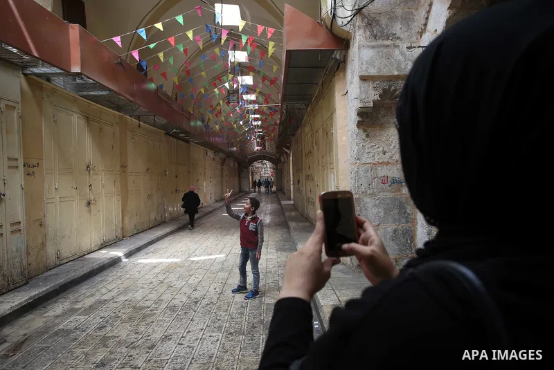 A Palestinian woman takes a selfie during closed shops during a general strike in support of Palestinian prisoners on hunger strike in Israeli jails, in the old market of the West Bank city of Nablus April 27, 2017. Phot...