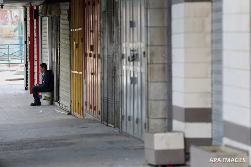 A Palestinian man sits a closed shops during a general strike in support of Palestinian prisoners on hunger strike in Israeli jails, in the old market of the West Bank city of Nablus April 27, 2017. Photo by Ayman Ameen