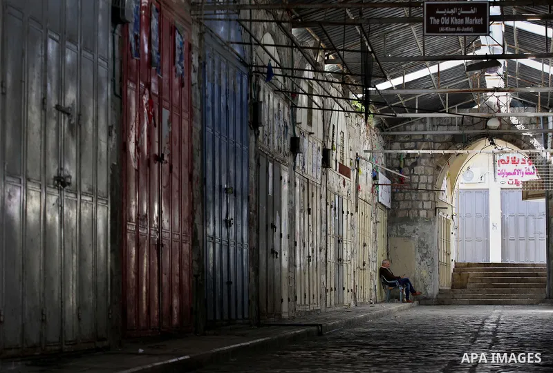 A Palestinian man sits a closed shops during a general strike in support of Palestinian prisoners on hunger strike in Israeli jails, in the old market of the West Bank city of Nablus April 27, 2017. Photo by Ayman Ameen