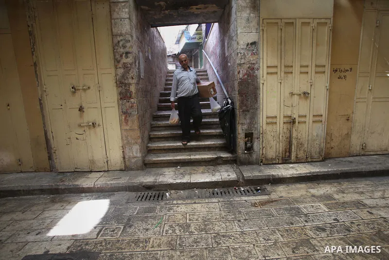 A Palestinian man walks past closed shops during a general strike in support of Palestinian prisoners on hunger strike in Israeli jails, in the old market of the West Bank city of Nablus April 27, 2017. Photo by Ayman Am...