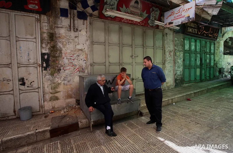 Palestinians sit a closed shops during a general strike in support of Palestinian prisoners on hunger strike in Israeli jails, in the old market of the West Bank city of Nablus April 27, 2017. Photo by Ayman Ameen