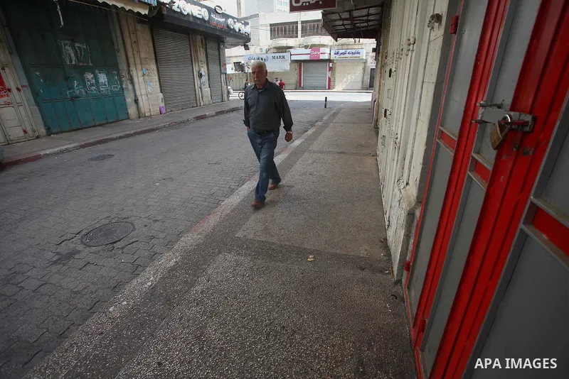 A Palestinian man walks past closed shops during a general strike in support of Palestinian prisoners on hunger strike in Israeli jails, in the old market of the West Bank city of Nablus April 27, 2017. Photo by Ayman Am...