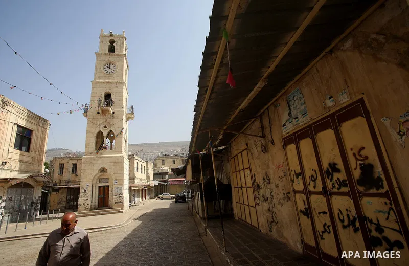 A Palestinian man walks past closed shops during a general strike in support of Palestinian prisoners on hunger strike in Israeli jails, in the old market of the West Bank city of Nablus April 27, 2017. Photo by Ayman Am...