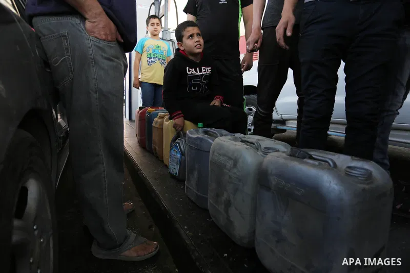 Palestinians wait to fill containers with fuel at a petrol station in Khan Younis in the southern Gaza Strip April 27, 2017. Photo by Ashraf Amra