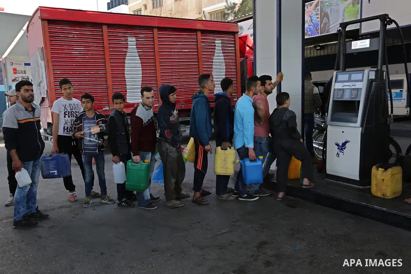 Palestinians wait to fill containers with fuel at a petrol station in Khan Younis in the southern Gaza Strip April 27, 2017. Photo by Ashraf Amra