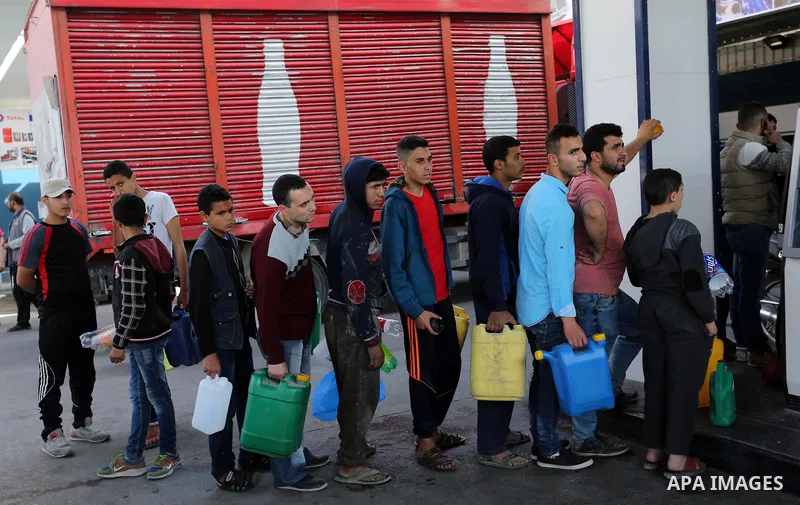 Palestinians wait to fill containers with fuel at a petrol station in Khan Younis in the southern Gaza Strip April 27, 2017. Photo by Ashraf Amra
