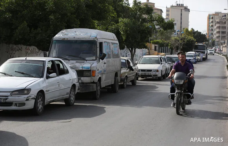 Palestinians wait to fill containers with fuel at a petrol station in Khan Younis in the southern Gaza Strip April 27, 2017. Photo by Ashraf Amra