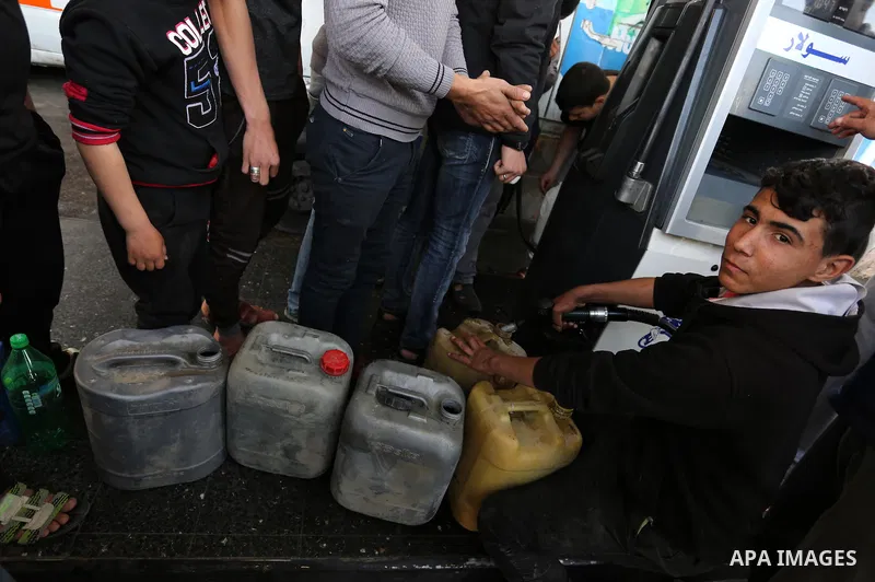 Palestinians wait to fill containers with fuel at a petrol station in Khan Younis in the southern Gaza Strip April 27, 2017. Photo by Ashraf Amra