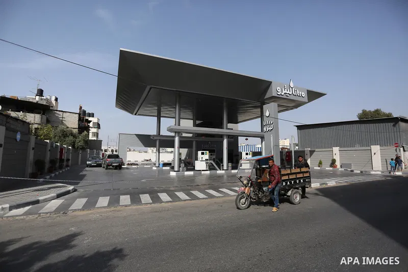 Palestinians wait to fill containers with fuel at a petrol station in Khan Younis in the southern Gaza Strip April 27, 2017. Photo by Ashraf Amra