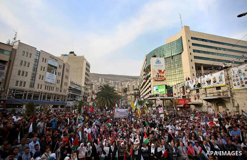 Protesters hold Palestine flags as they take part in a protest to show solidarity with Palestinian prisoners on hunger strike in Israeli jails, in the West Bank city of Nablus on April 27, 2017. Photo by Ayman Ameen