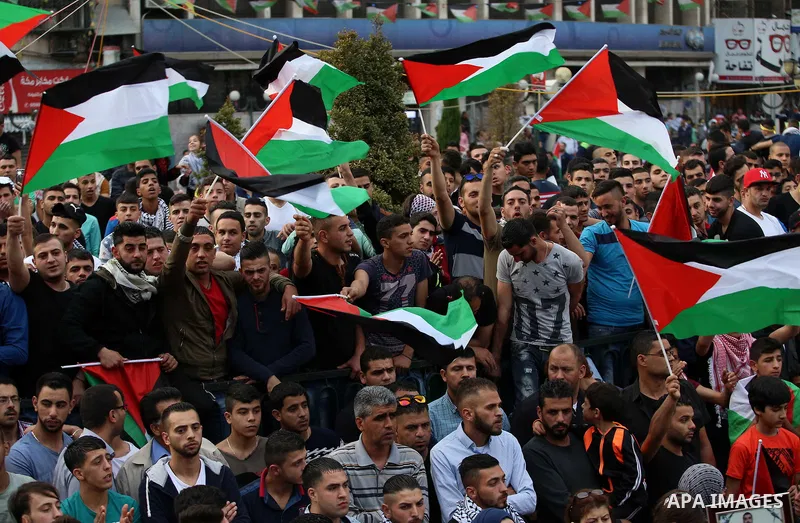 Protesters hold Palestine flags as they take part in a protest to show solidarity with Palestinian prisoners on hunger strike in Israeli jails, in the West Bank city of Nablus on April 27, 2017. Photo by Ayman Ameen