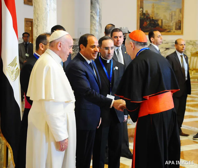 Egyptian President Abdel Fattah al-Sisi shakes hands with clergymen as Pope Francis looks on during a meeting at the presidential palace in Cairo, during an official visit to Egypt on April 28, 2017. Pope Francis began a...