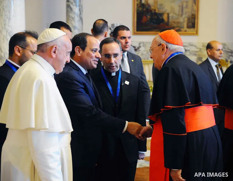 Egyptian President Abdel Fattah al-Sisi shakes hands with clergymen as Pope Francis looks on during a meeting at the presidential palace in Cairo, during an official visit to Egypt on April 28, 2017. Pope Francis began a...