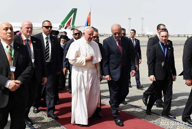 Pope Francis disembarks from his plane upon his arrival at Cairo's International Airport on April 28, 2017, during an official visit to Egypt. Pope Francis began a visit to Egypt to promote "unity and fraternity" among M...