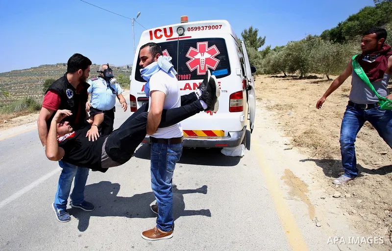A Palestinian protester is evacuated after he was wounded during clashes with Israeli security forces at a protest in support of Palestinian prisoners on hunger strike in Israeli jails, in the West Bank village of al-Naq...