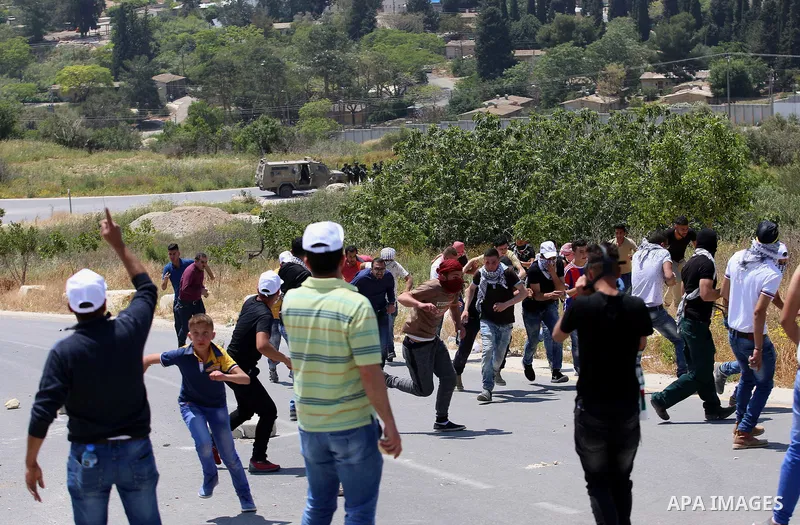 Palestinian protesters hurl stones towards Israeli security forces during clashes at a protest in support of Palestinian prisoners on hunger strike in Israeli jails, in the West Bank village of al-Naqoura, near Nablus on...