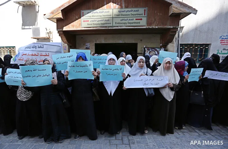 Palestinian women hold placards during a protest demanding end an Israeli blockade of the Gaza Strip, at Al-Shifa hospital in Gaza City on April 29, 2017. Photo by Ashraf Amra