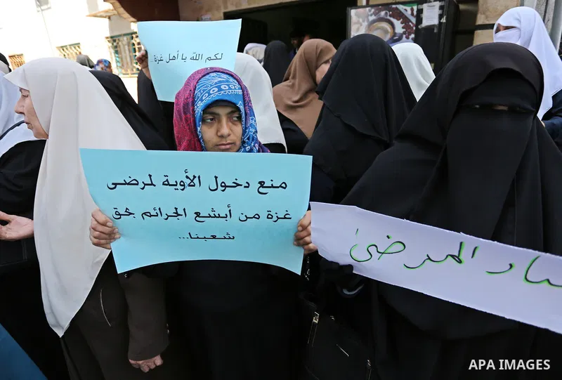 Palestinian women hold placards during a protest demanding end an Israeli blockade of the Gaza Strip, at Al-Shifa hospital in Gaza City on April 29, 2017. Photo by Ashraf Amra