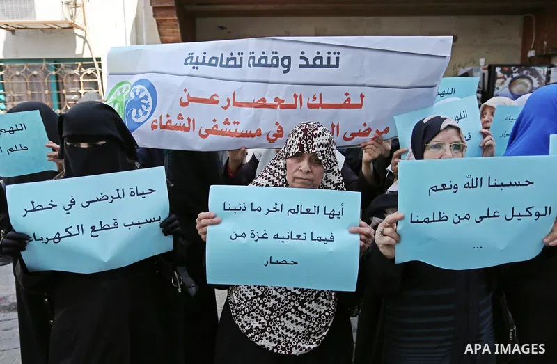 Palestinian women hold placards during a protest demanding end an Israeli blockade of the Gaza Strip, at Al-Shifa hospital in Gaza City on April 29, 2017. Photo by Ashraf Amra