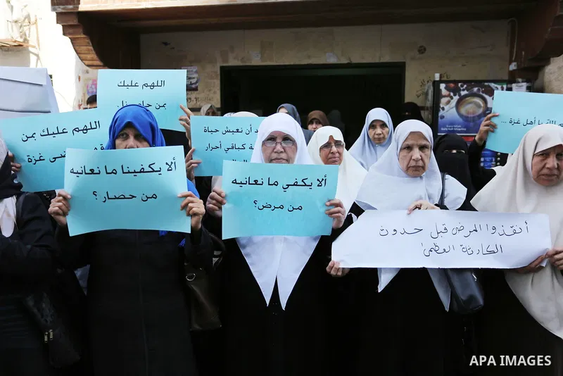 Palestinian women hold placards during a protest demanding end an Israeli blockade of the Gaza Strip, at Al-Shifa hospital in Gaza City on April 29, 2017. Photo by Ashraf Amra