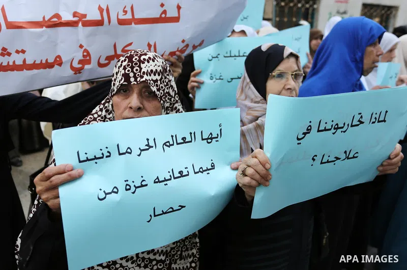 Palestinian women hold placards during a protest demanding end an Israeli blockade of the Gaza Strip, at Al-Shifa hospital in Gaza City on April 29, 2017. Photo by Ashraf Amra
