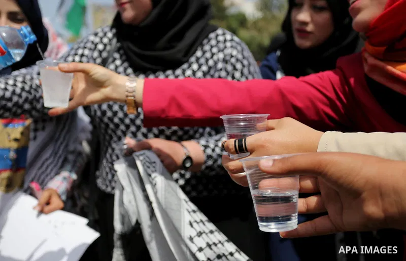 Palestinians drink water and salt during a protest to show solidarity with Palestinian prisoners on hunger strike in Israeli jails, in Gaza city on April 30, 2017. Photo by Ashraf Amra
