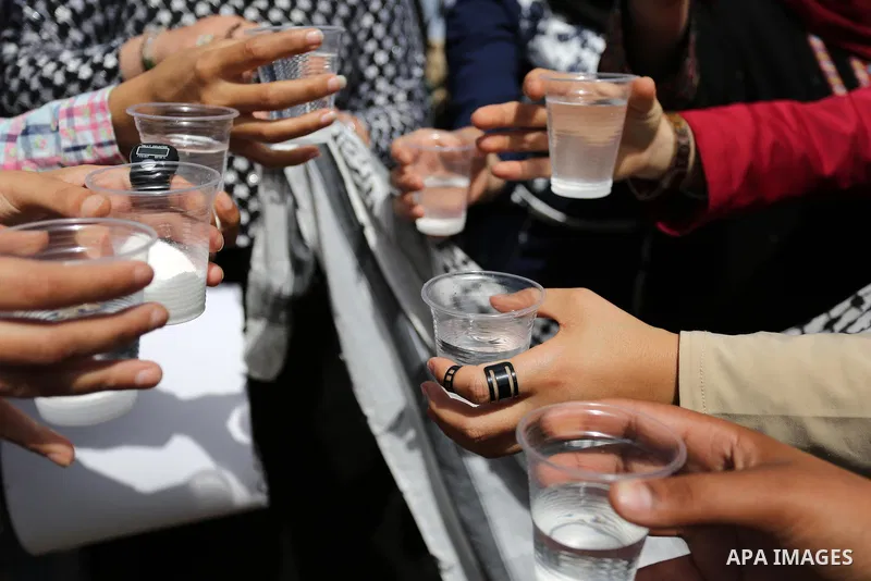 Palestinians drink water and salt during a protest to show solidarity with Palestinian prisoners on hunger strike in Israeli jails, in Gaza city on April 30, 2017. Photo by Ashraf Amra