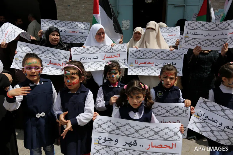 Palestinian children hold banners during a protest to demand the end of Israeli blockade of the Gaza Strip and against the worsening crisis of power outages in Gaza City, in Gaza city on April 30, 2017. Photo by Ashraf A...
