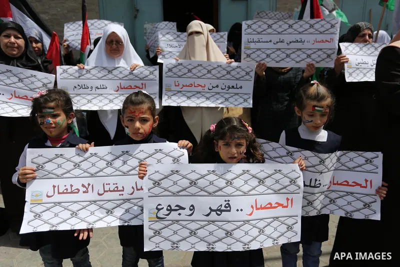 Palestinian children hold banners during a protest to demand the end of Israeli blockade of the Gaza Strip and against the worsening crisis of power outages in Gaza City, in Gaza city on April 30, 2017. Photo by Ashraf A...