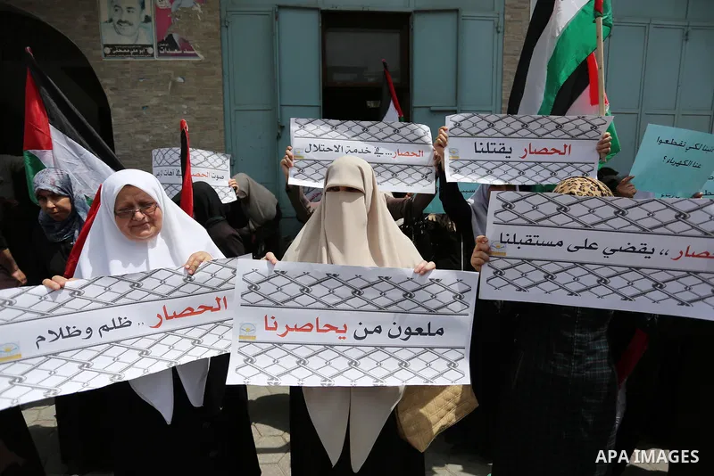 Palestinians hold banners during a protest to demand the end of Israeli blockade of the Gaza Strip and against the worsening crisis of power outages in Gaza City, in Gaza city on April 30, 2017. Photo by Ashraf Amra