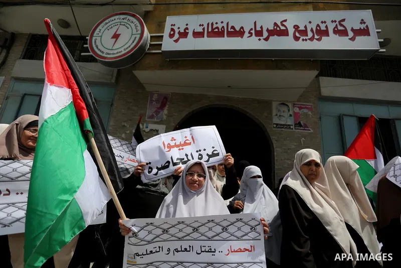 Palestinians hold banners during a protest to demand the end of Israeli blockade of the Gaza Strip and against the worsening crisis of power outages in Gaza City, in Gaza city on April 30, 2017. Photo by Ashraf Amra