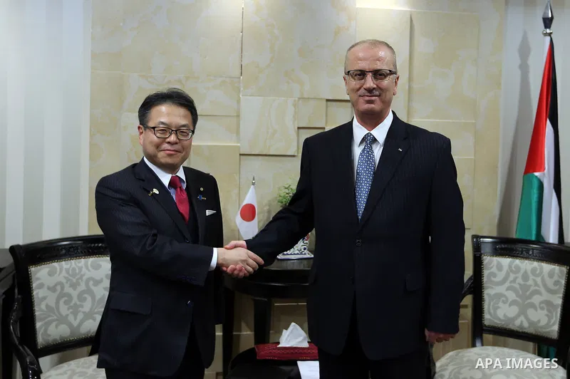 Palestinian Prime Minister Rami Hamdallah shakes hands with Japanese State Minister of Economy, Trade and Industry Hiroshige Seko in the West Bank city of Ramallah on May 02, 2017. Photo by Prime Minister Office