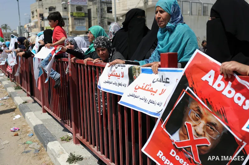 Palestinians hold a poster depicting Palestinian President Mahmoud Abbas during a protest against the blockade in Dair Al Balah, in the center of Gaza strip on May 2, 2017 demanding an end to the one-decade-old Israeli s...
