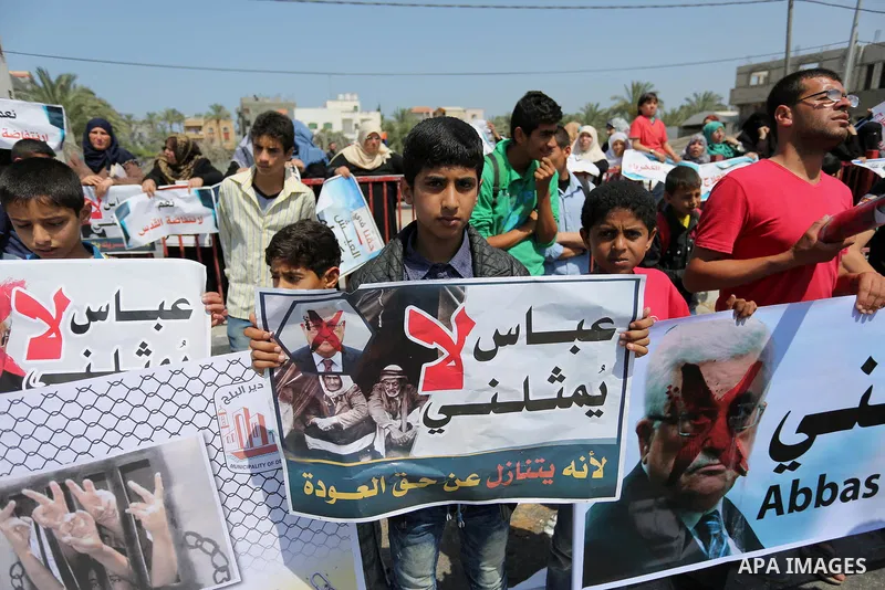 Palestinians hold a poster depicting Palestinian President Mahmoud Abbas during a protest against the blockade in Dair Al Balah, in the center of Gaza strip on May 2, 2017 demanding an end to the one-decade-old Israeli s...