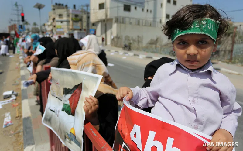 Palestinians hold a poster depicting Palestinian President Mahmoud Abbas during a protest against the blockade in Dair Al Balah, in the center of Gaza strip on May 2, 2017 demanding an end to the one-decade-old Israeli s...