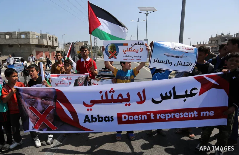 Palestinians hold a poster depicting Palestinian President Mahmoud Abbas during a protest against the blockade in Dair Al Balah, in the center of Gaza strip on May 2, 2017 demanding an end to the one-decade-old Israeli s...