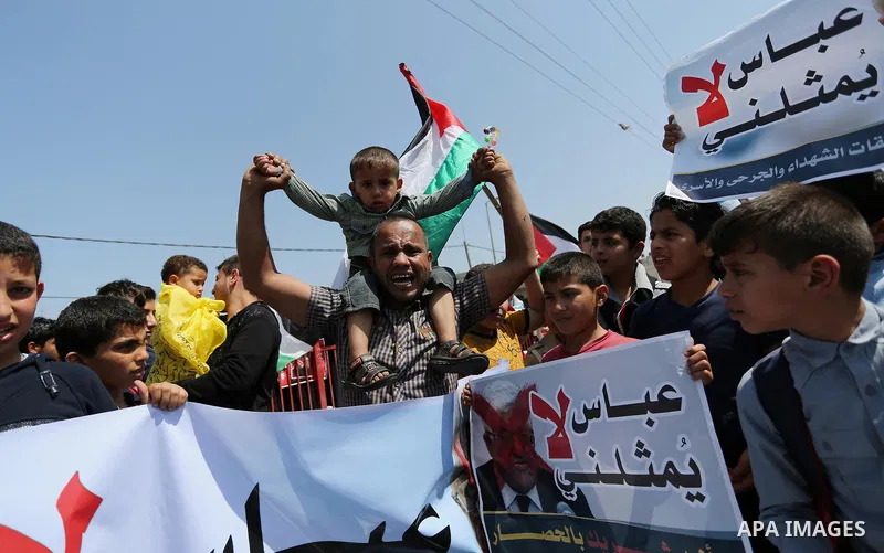Palestinians hold a poster depicting Palestinian President Mahmoud Abbas during a protest against the blockade in Dair Al Balah, in the center of Gaza strip on May 2, 2017 demanding an end to the one-decade-old Israeli s...