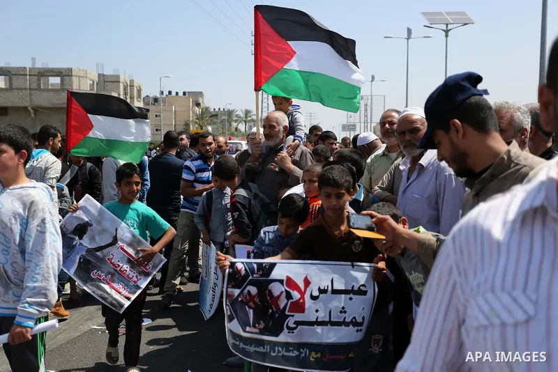 Palestinians hold a poster depicting Palestinian President Mahmoud Abbas during a protest against the blockade in Dair Al Balah, in the center of Gaza strip on May 2, 2017 demanding an end to the one-decade-old Israeli s...