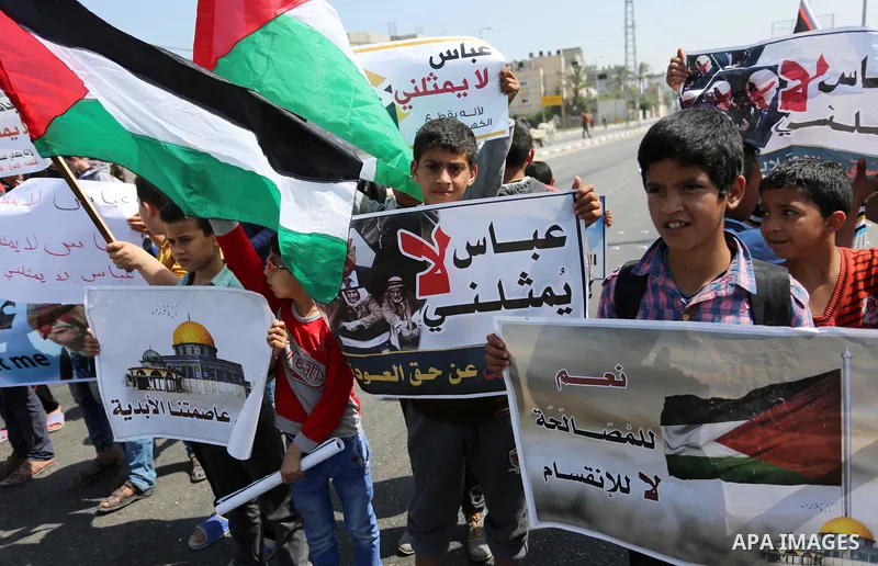 Palestinians hold a poster depicting Palestinian President Mahmoud Abbas during a protest against the blockade in Dair Al Balah, in the center of Gaza strip on May 2, 2017 demanding an end to the one-decade-old Israeli s...