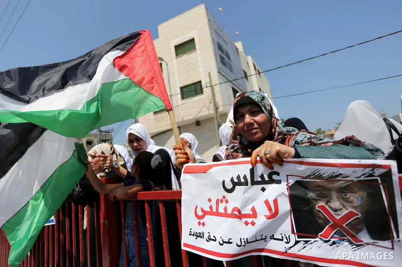 Palestinians hold a poster depicting Palestinian President Mahmoud Abbas during a protest against the blockade in Dair Al Balah, in the center of Gaza strip on May 2, 2017 demanding an end to the one-decade-old Israeli s...