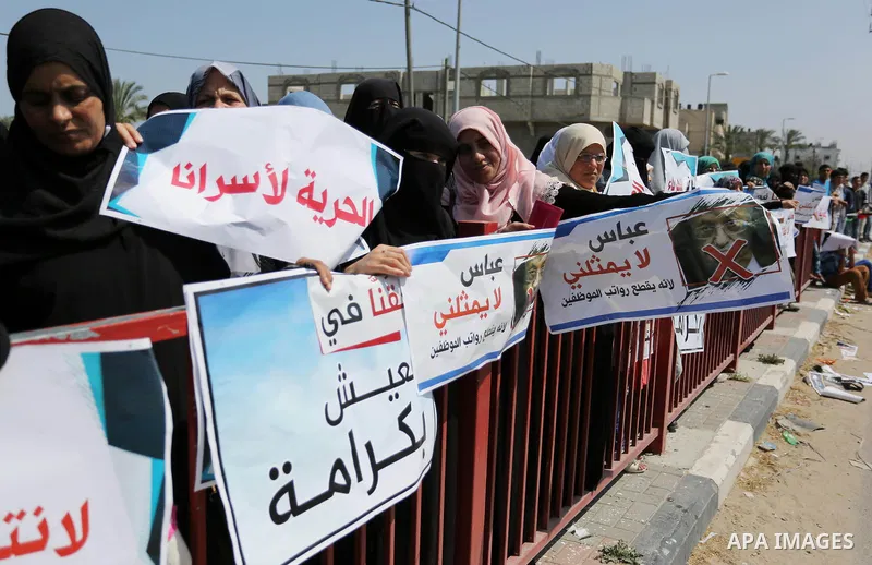 Palestinians hold a poster depicting Palestinian President Mahmoud Abbas during a protest against the blockade in Dair Al Balah, in the center of Gaza strip on May 2, 2017 demanding an end to the one-decade-old Israeli s...
