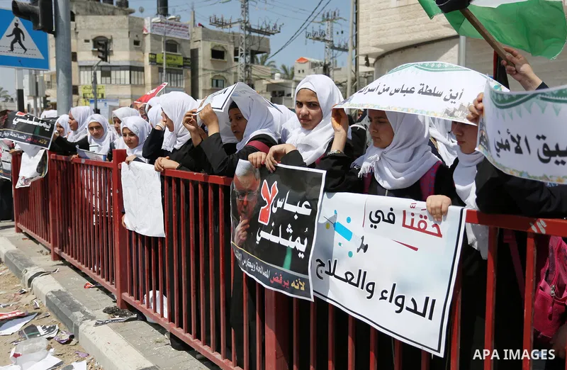 Palestinians hold a poster depicting Palestinian President Mahmoud Abbas during a protest against the blockade in Dair Al Balah, in the center of Gaza strip on May 2, 2017 demanding an end to the one-decade-old Israeli s...