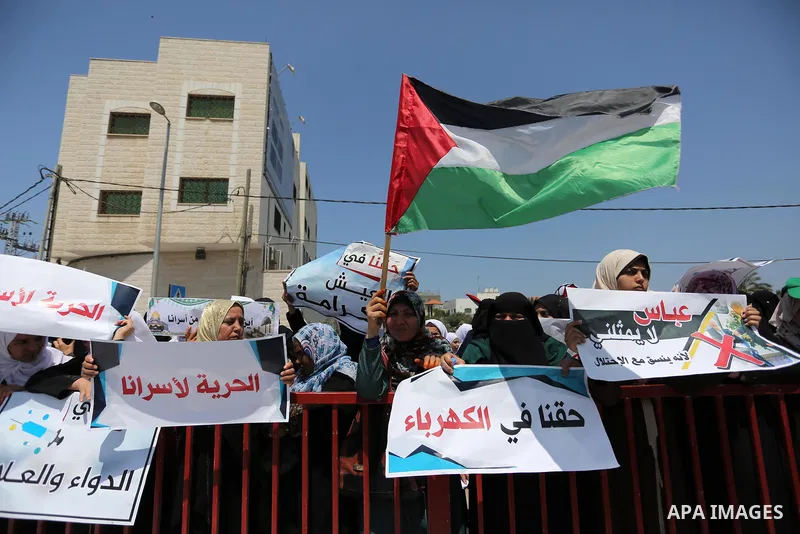 Palestinians hold a poster depicting Palestinian President Mahmoud Abbas during a protest against the blockade in Dair Al Balah, in the center of Gaza strip on May 2, 2017 demanding an end to the one-decade-old Israeli s...