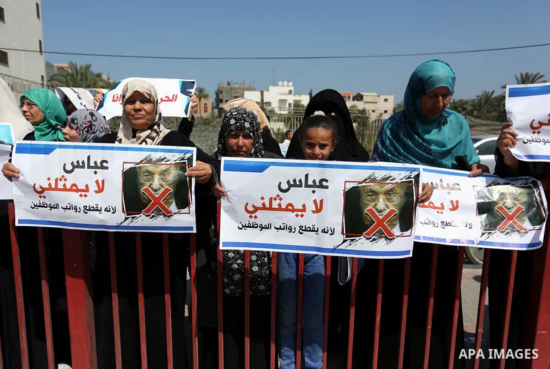 Palestinians hold a poster depicting Palestinian President Mahmoud Abbas during a protest against the blockade in Dair Al Balah, in the center of Gaza strip on May 2, 2017 demanding an end to the one-decade-old Israeli s...