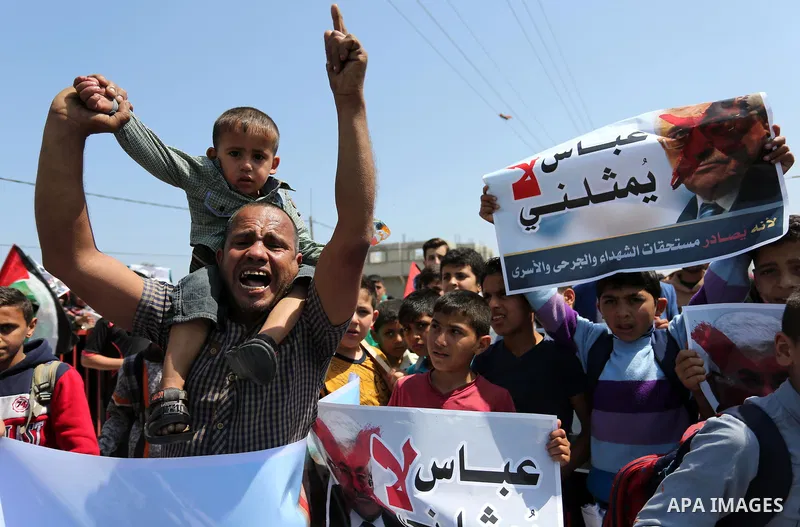 Palestinians hold a poster depicting Palestinian President Mahmoud Abbas during a protest against the blockade in Dair Al Balah, in the center of Gaza strip on May 2, 2017 demanding an end to the one-decade-old Israeli s...