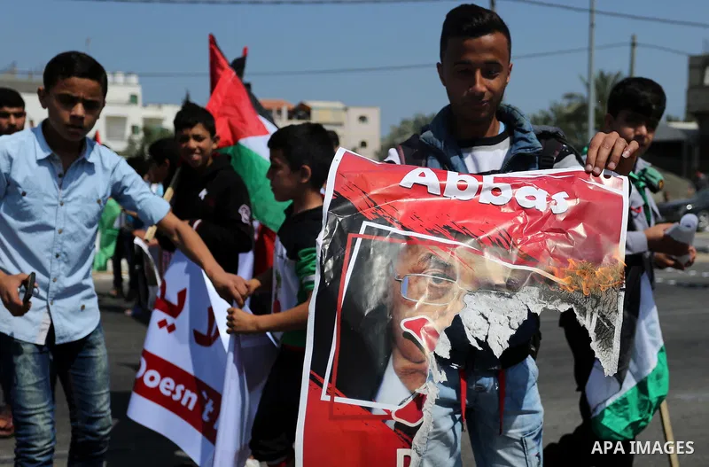 Palestinians hold a poster depicting Palestinian President Mahmoud Abbas during a protest against the blockade in Dair Al Balah, in the center of Gaza strip on May 2, 2017 demanding an end to the one-decade-old Israeli s...