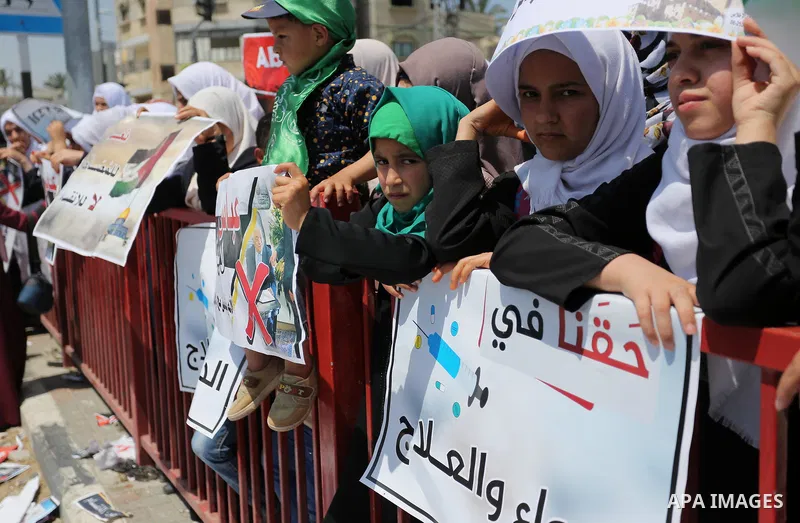 Palestinians hold a poster depicting Palestinian President Mahmoud Abbas during a protest against the blockade in Dair Al Balah, in the center of Gaza strip on May 2, 2017 demanding an end to the one-decade-old Israeli s...