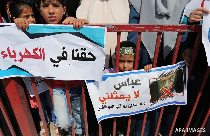 Palestinians hold a poster depicting Palestinian President Mahmoud Abbas during a protest against the blockade in Dair Al Balah, in the center of Gaza strip on May 2, 2017 demanding an end to the one-decade-old Israeli s...