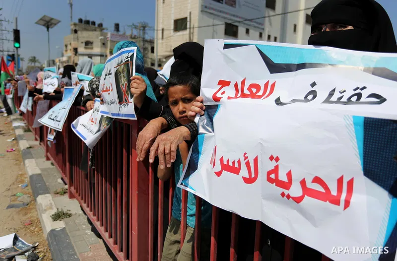 Palestinians hold a poster depicting Palestinian President Mahmoud Abbas during a protest against the blockade in Dair Al Balah, in the center of Gaza strip on May 2, 2017 demanding an end to the one-decade-old Israeli s...