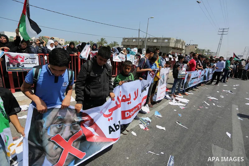 Palestinians hold a poster depicting Palestinian President Mahmoud Abbas during a protest against the blockade in Dair Al Balah, in the center of Gaza strip on May 2, 2017 demanding an end to the one-decade-old Israeli s...